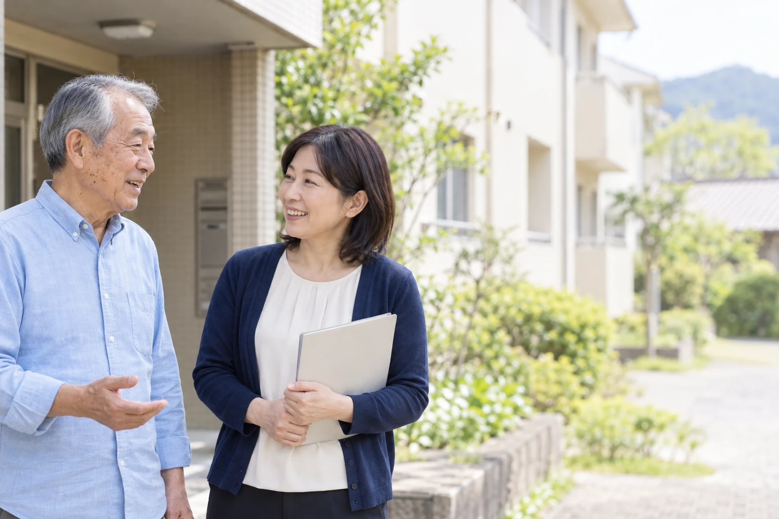 住まいの玄関で笑顔を交わす入居者と支援者